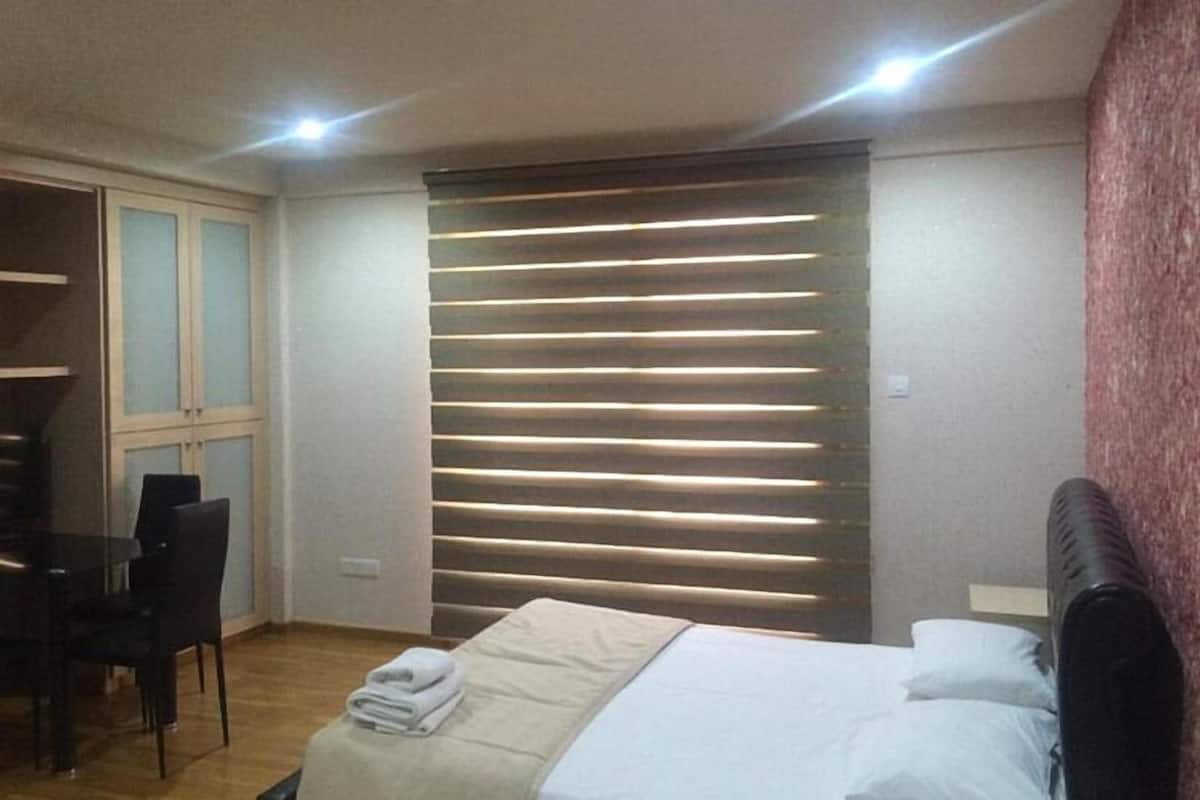 Un dormitorio con cama, escritorio y silla.