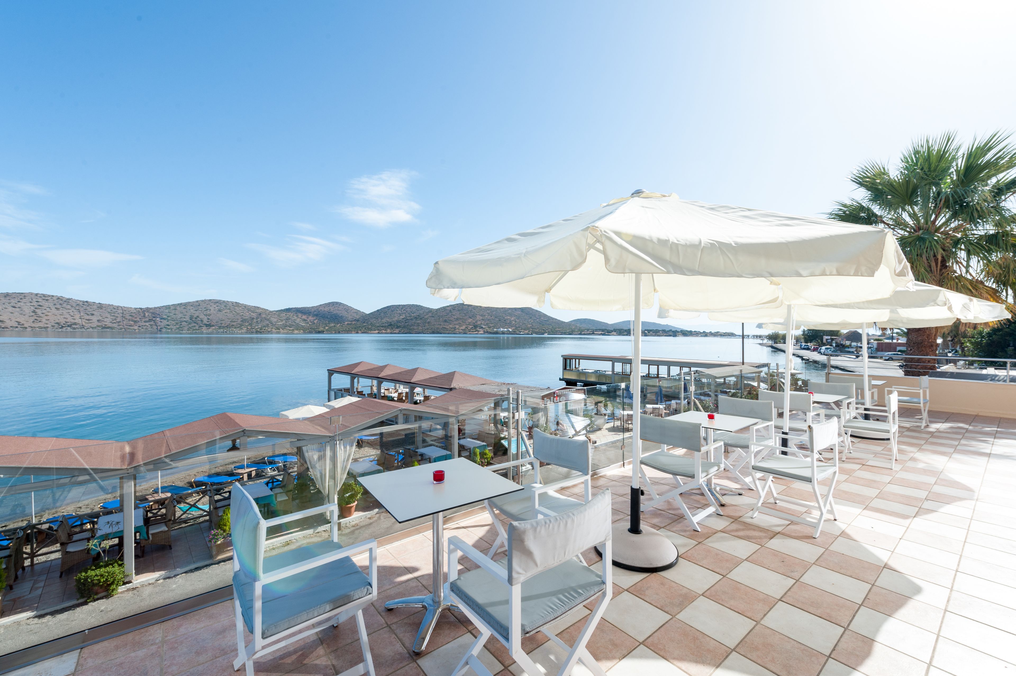 A terrace with outdoor seating and a view of the sea.