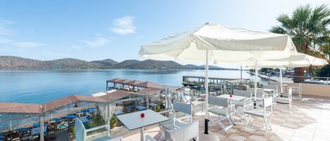 A terrace with outdoor seating and a view of the sea.
