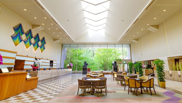 A spacious lobby with a checkered floor, a reception desk, seating area, and large windows offering a view of greenery. - Hotel Epinard Nasu (Nasu)