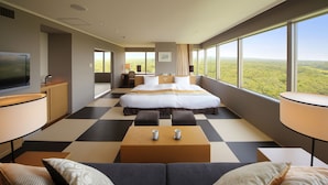 A hotel room with a large bed, a TV, a desk, and a view of the forest. - Hotel Epinard Nasu (Nasu)