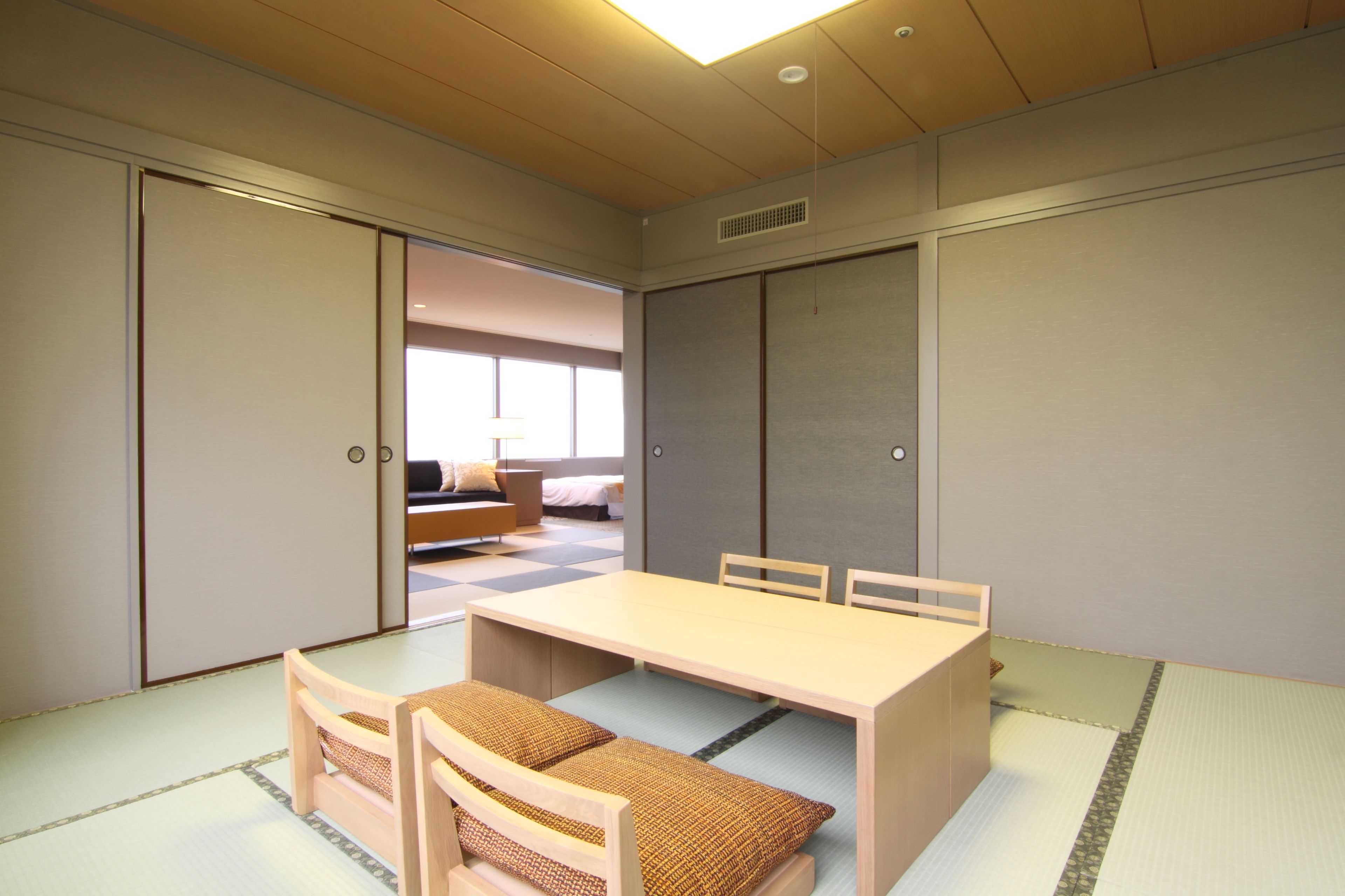 Una habitación tradicional japonesa con suelo de tatami, una mesa baja y una futón.