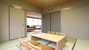 Una habitación tradicional japonesa con suelo de tatami, una mesa baja y una futón.