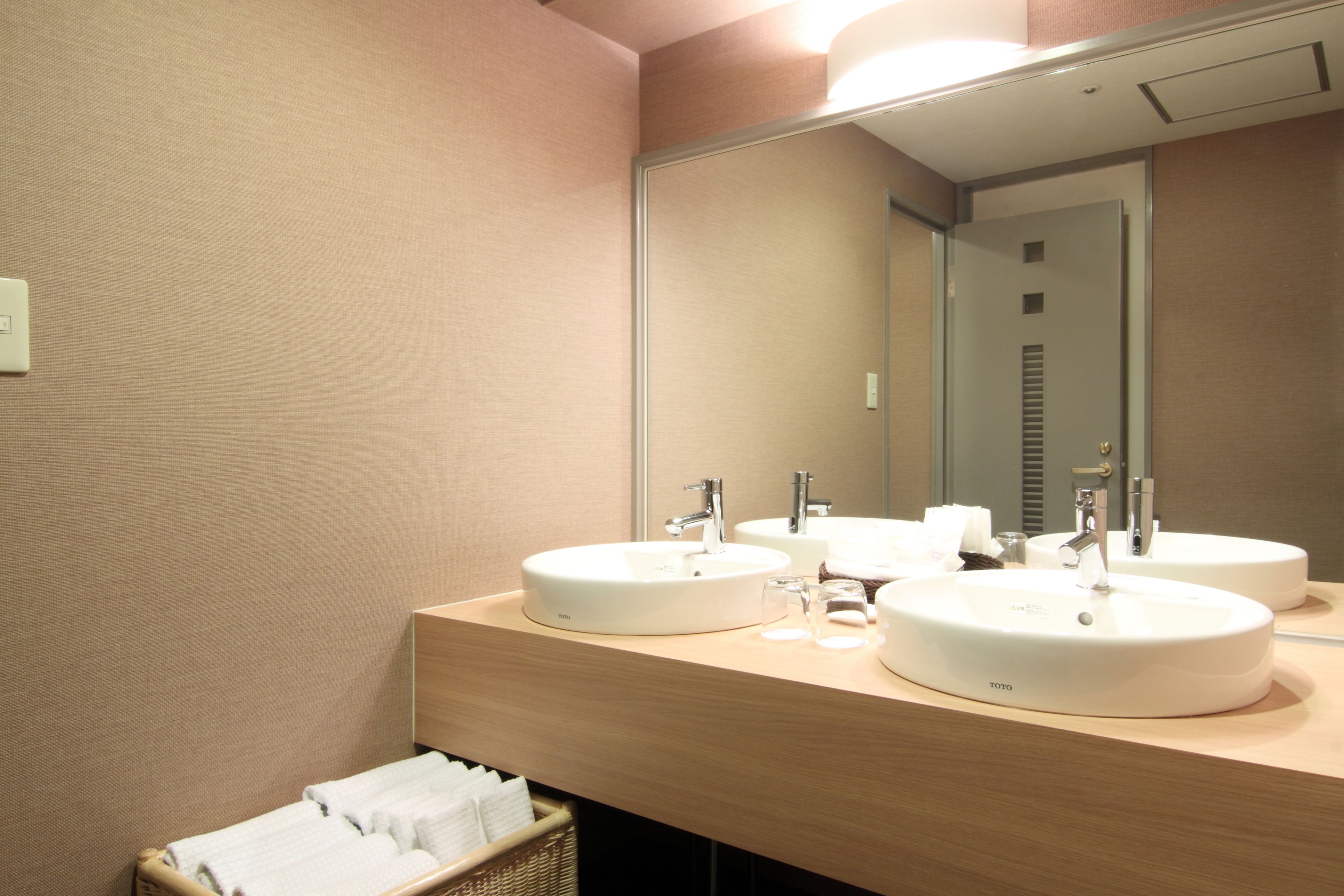 Une salle de bain d’hôtel avec deux lavabos, un miroir et un porte-serviettes.