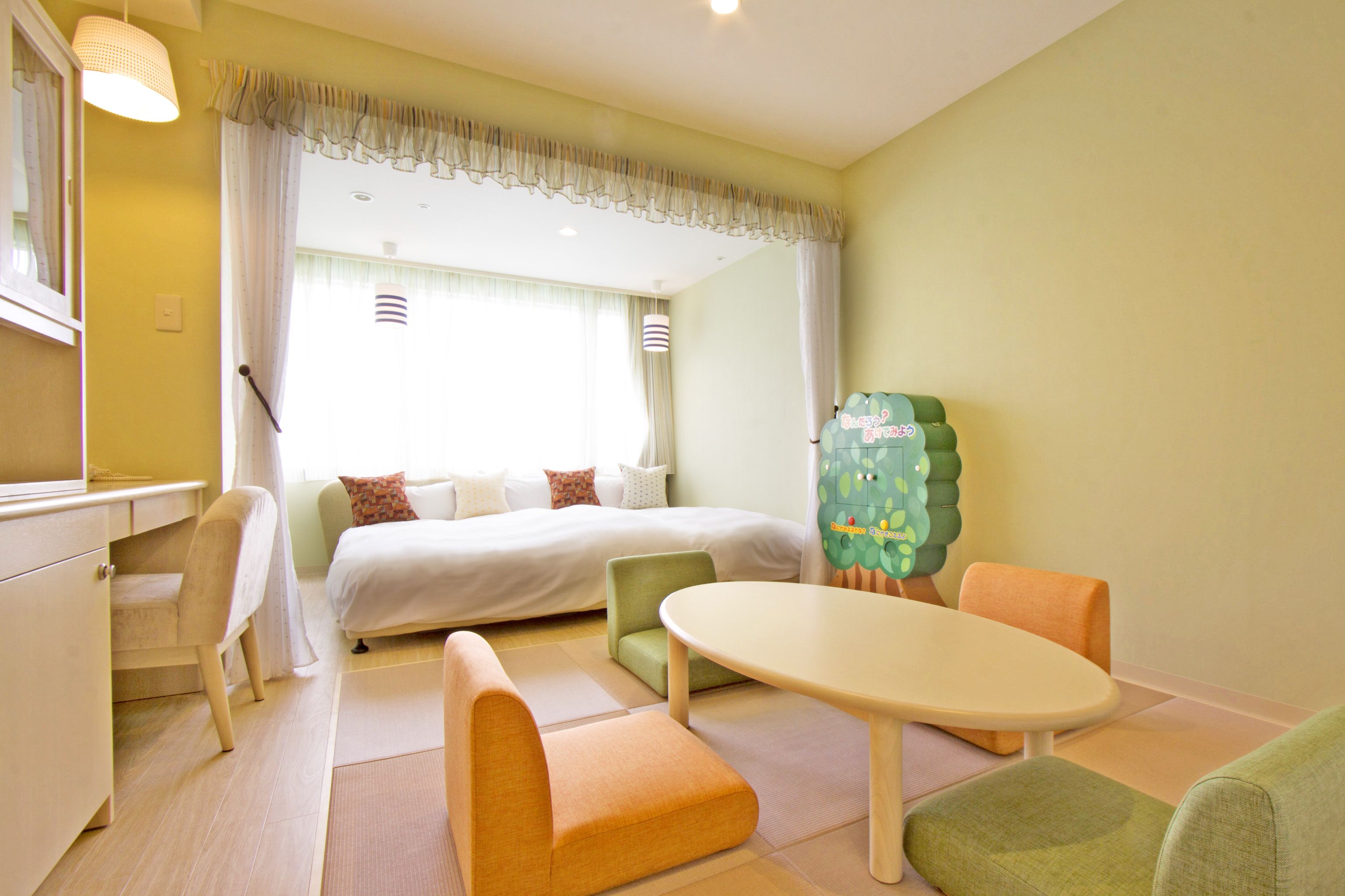 Una habitación de hotel con una cama, un escritorio, una silla, una mesa y un armario verde.