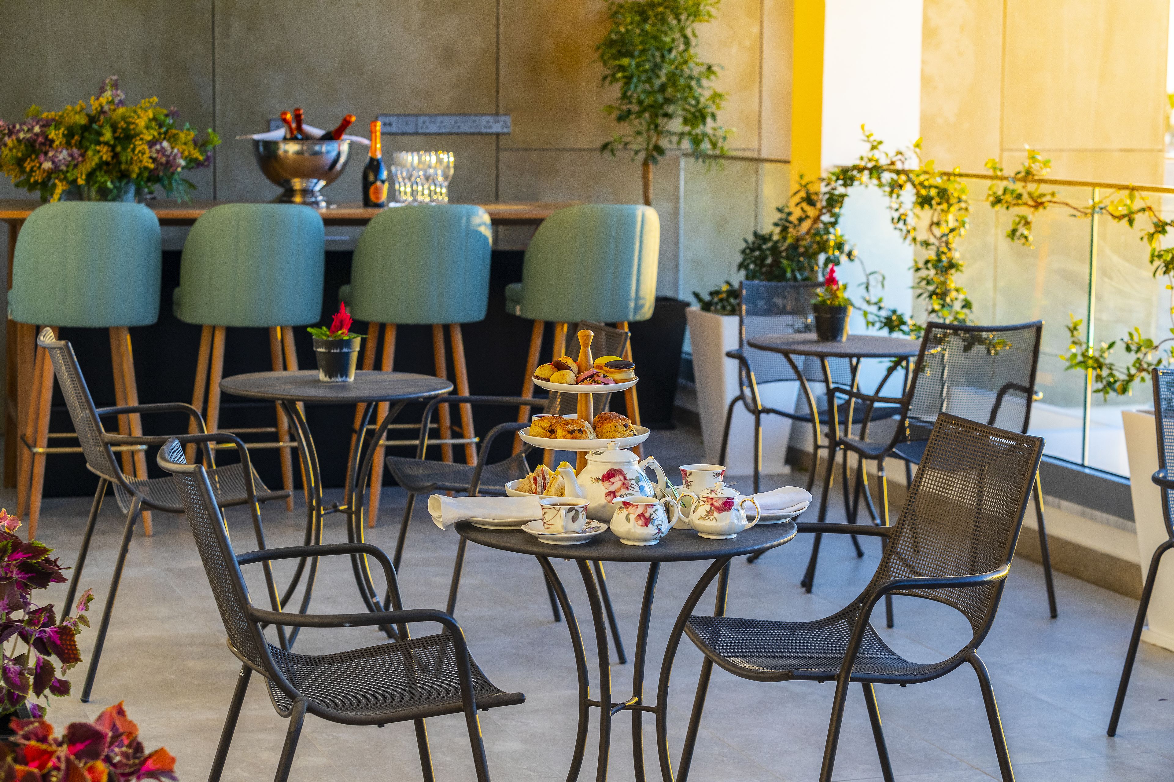 Un café doté d’une terrasse, avec des tables et des chaises, où une variété de plats et de boissons sont présentés.