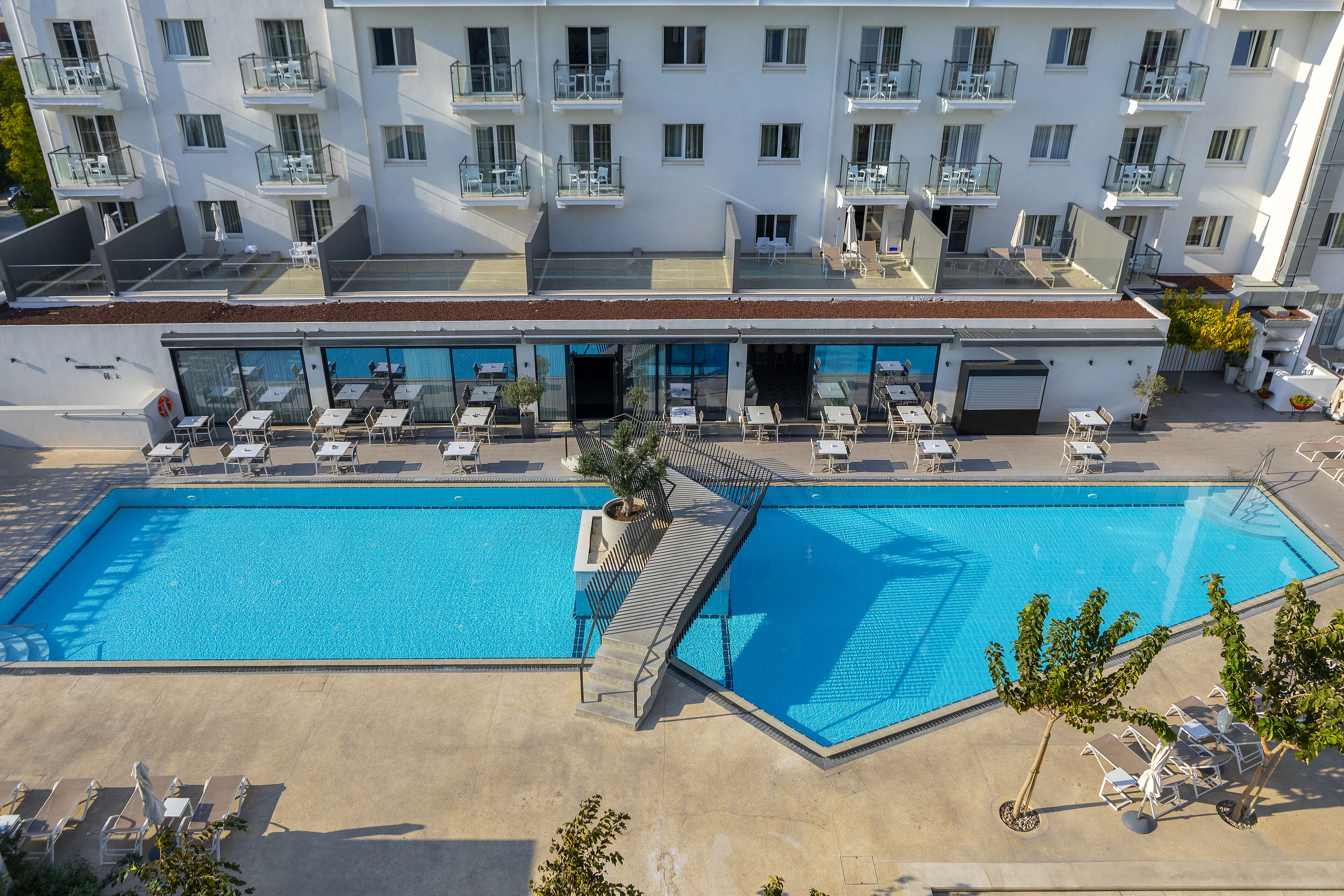 Un hôtel doté d’une grande piscine extérieure, de nombreux balcons et d’espaces de détente en plein air.