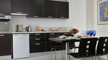 A modern kitchen with dark cabinetry, a built-in oven, and a dishwasher.