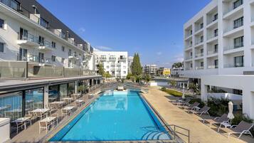 Een buitenzwembad, zwembadcabana's (toeslag) en parasols bij het zwembad