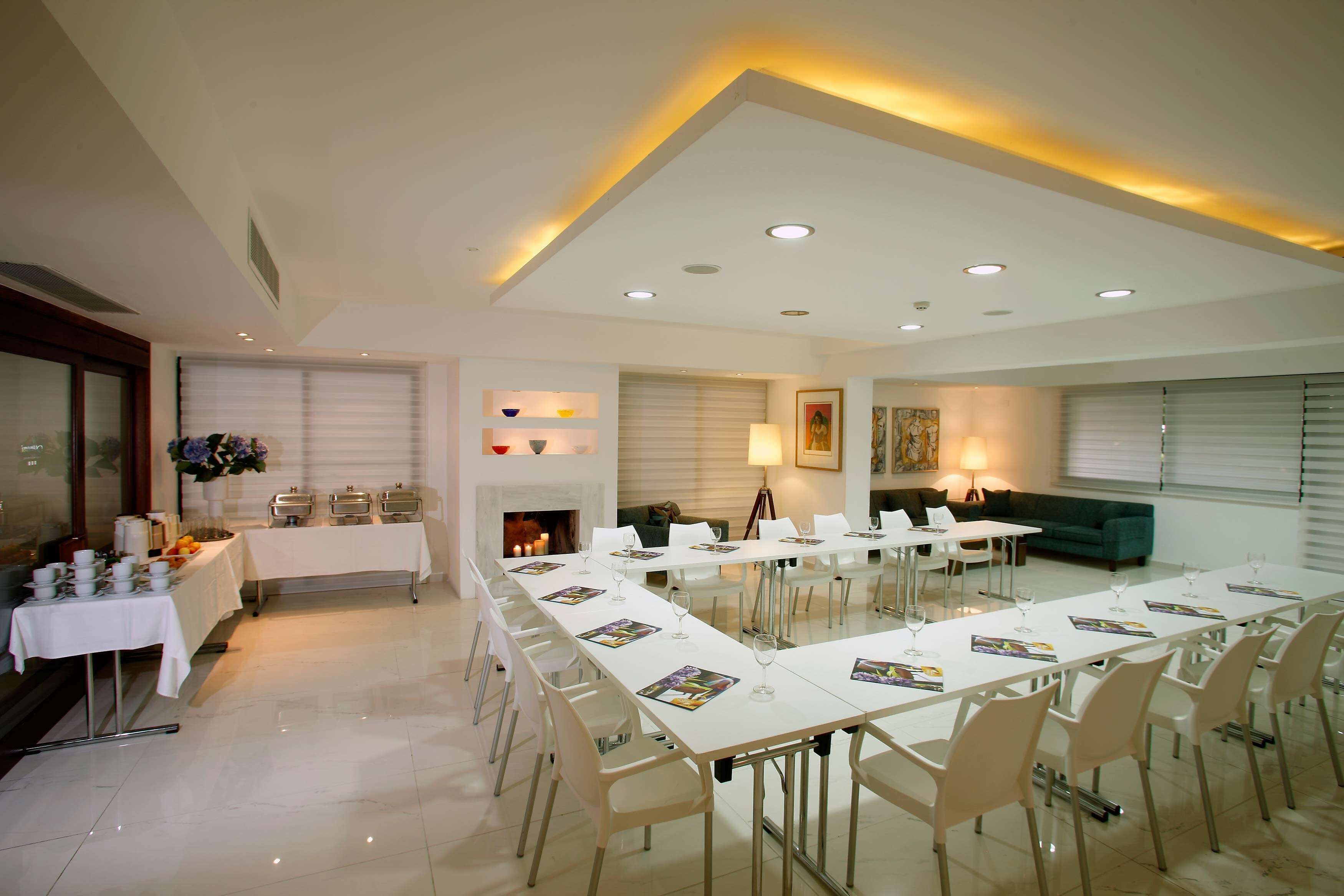 A spacious conference room with a long table, chairs, and a fireplace.