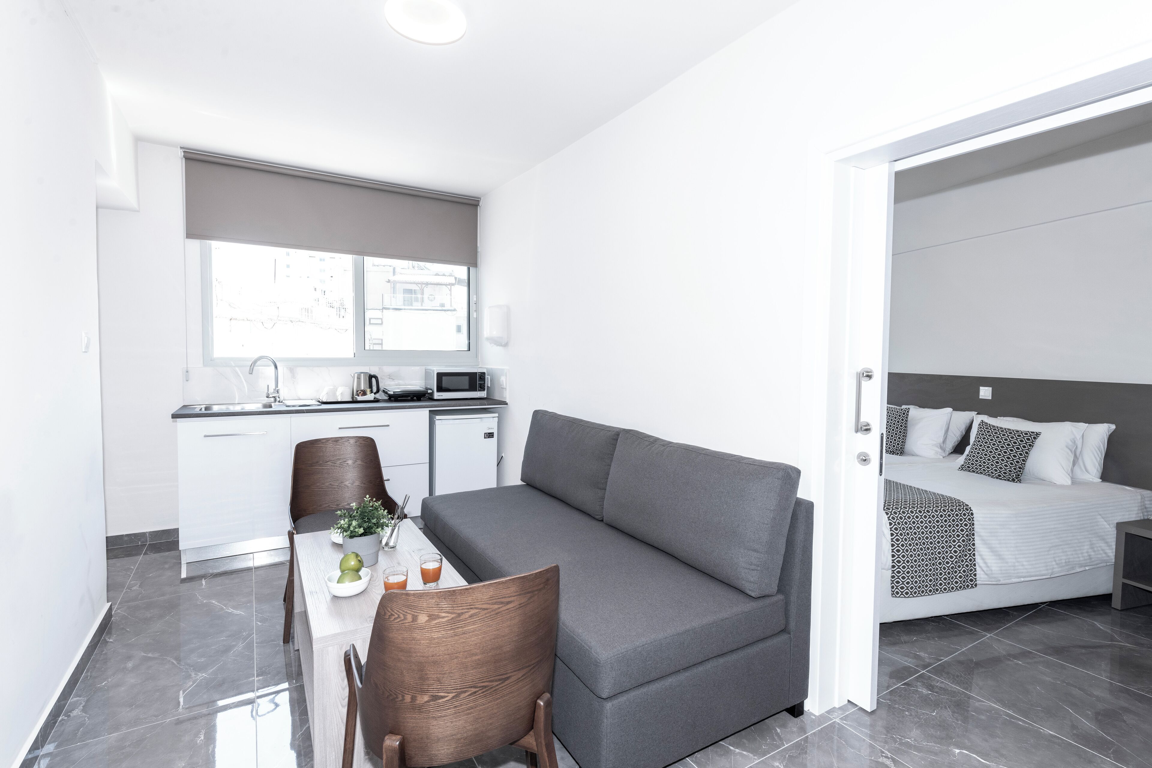 A compact living space with a kitchenette, a dining area, and a bed.