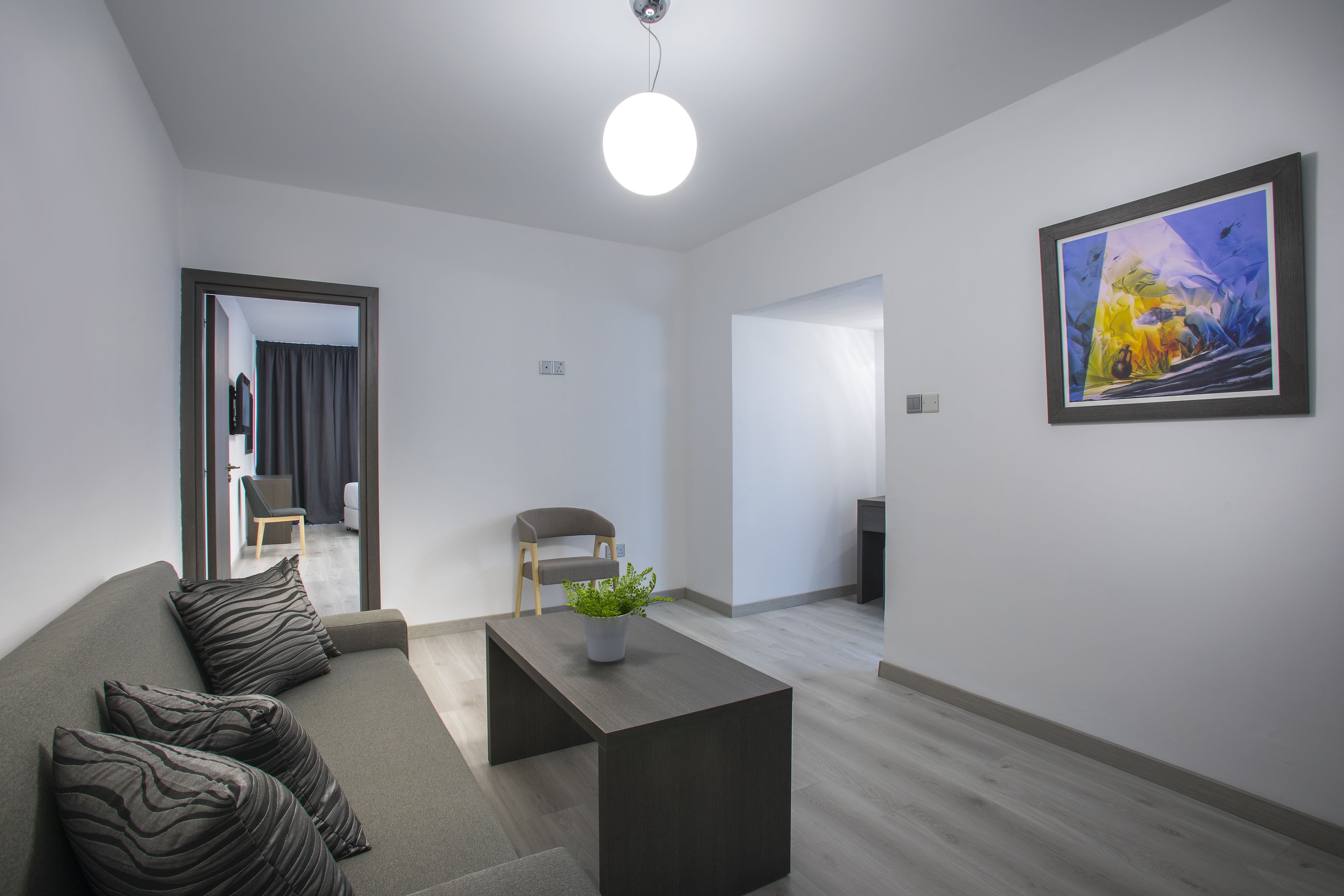 Ein modernes Wohnzimmer mit Sofa, Couchtisch und einem Gemälde an der Wand.
