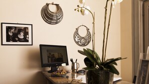 Un bureau avec un ordinateur, des clés, une plante et des objets décoratifs.