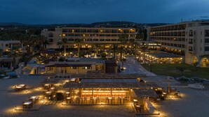 Un hotel con zonas de comedor al aire libre, varios pisos y vistas del paisaje circundante.