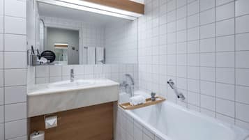 Un baño moderno con dos lavamanos, un espejo grande y una bañera.