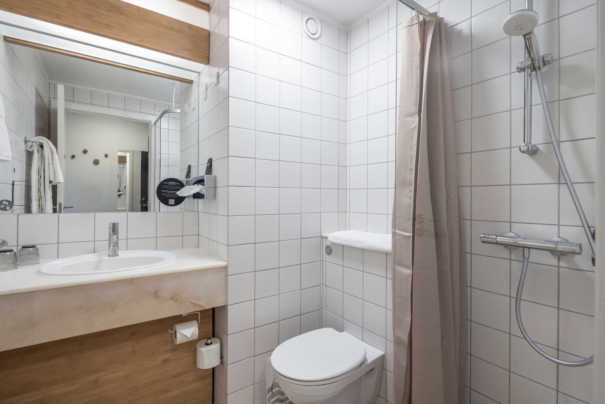 A bathroom with a toilet, sink, and shower.