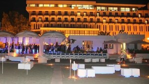 A hotel with a modern design, featuring a large building with multiple balconies and a well-lit outdoor area with seating arrangements. - Grand Hotel Terme (Margherita di Savoia)