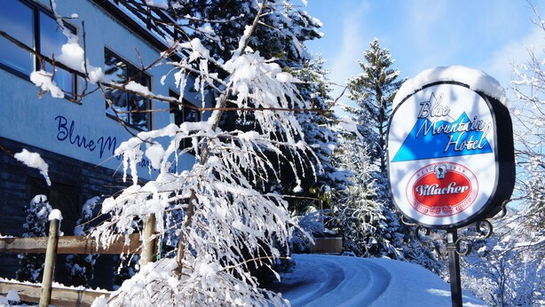 A sign for the Blue Mountain Hotel with a logo for Pilsacher beer. - Blue Mountain Hotel (Treffen)