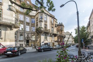 A street with historic buildings, parked cars, and bicycles. - Cracowdays (Kraków)