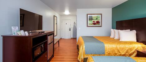 Una habitación de hotel con cama, televisión, escritorio y armario.