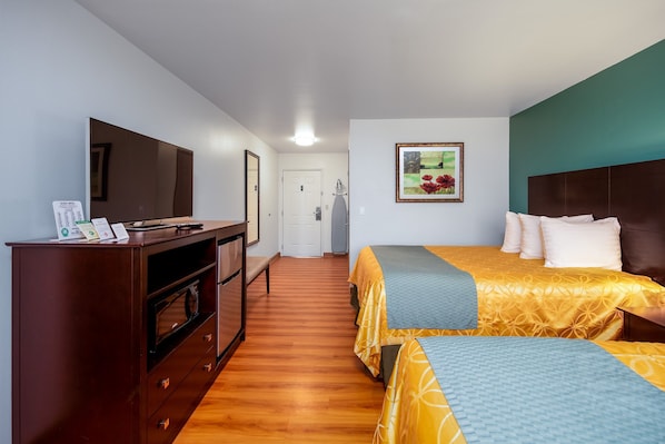 A hotel room with a bed, a TV, a desk, and a wardrobe.