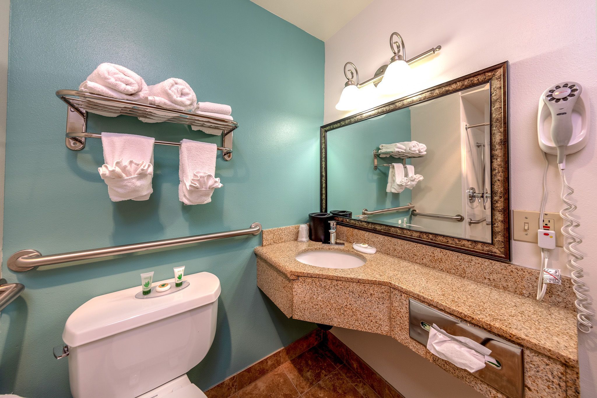 A bathroom with a toilet, sink, towel rack, and a hairdryer.