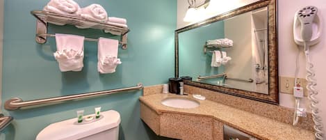 A bathroom with a toilet, sink, towel rack, and a hairdryer.
