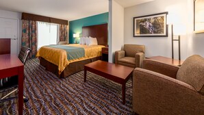 A hotel room with a bed, a desk, a chair, a table, and a picture on the wall. - Sunset Motel Hood River (Hood River)