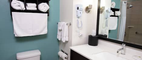 Ein Badezimmer mit Toilette, Waschbecken, Handtuchhalter und Fön.