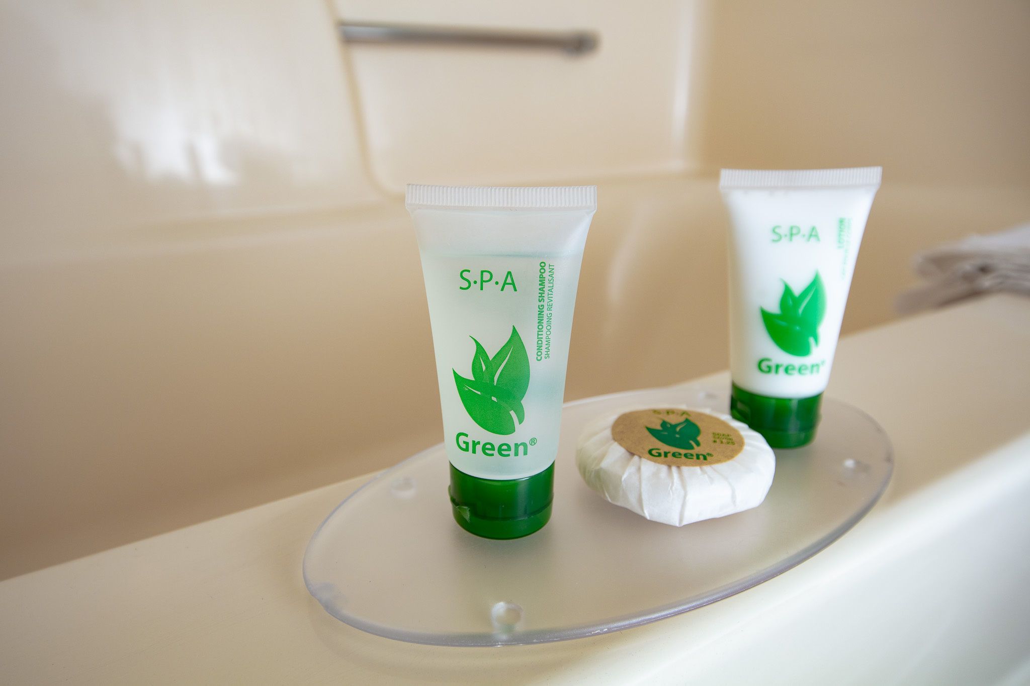 Two tubes of S.P.A. Green shampoo and a bar of soap on a bathroom counter.