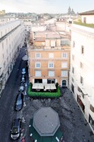 A narrow street with parked cars and a building labeled "ALBERGO S. CHIARA".