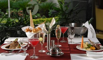 A table set for a meal with various dishes, drinks, and a decorative centerpiece.