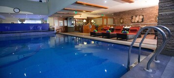 A swimming pool with lounge chairs and a bar area.