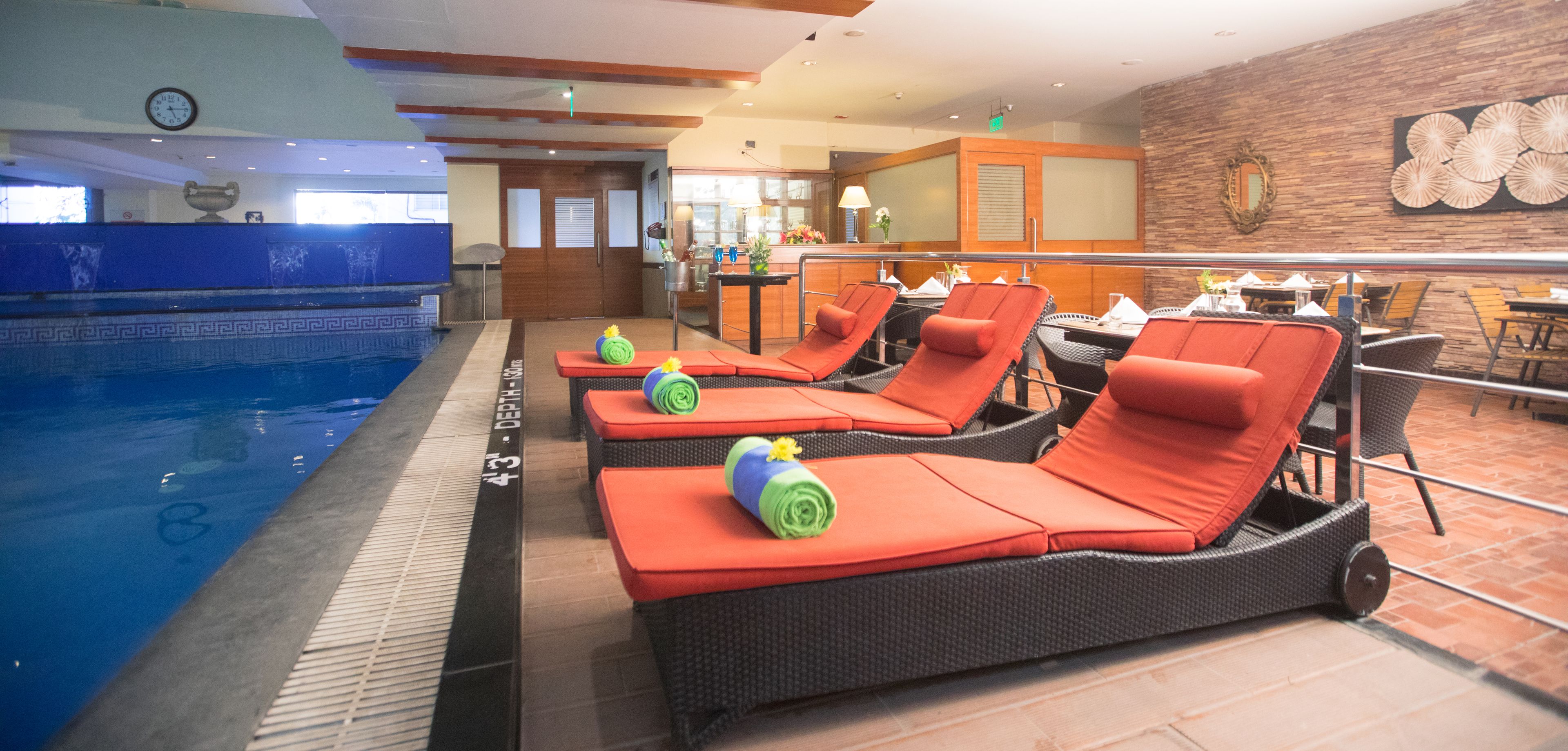 A poolside area with lounge chairs, a bar, and a dining area.