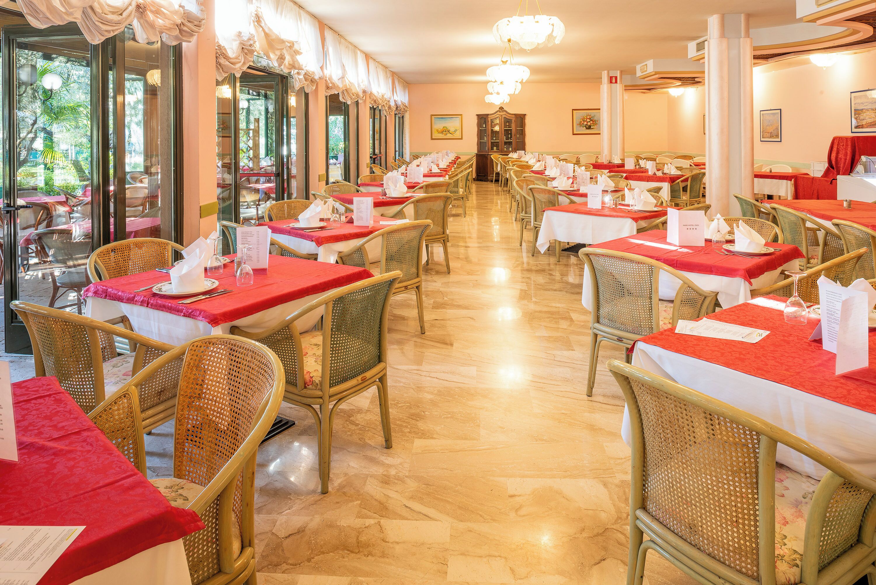 Ein Restaurant mit mehreren Tischen und Stühlen, die in Reihen angeordnet sind, mit Speisekarten auf jedem Tisch.