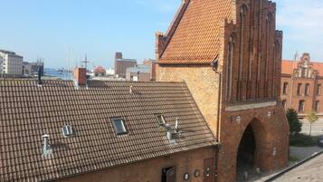 A historic brick building with a tiled roof and a prominent tower.