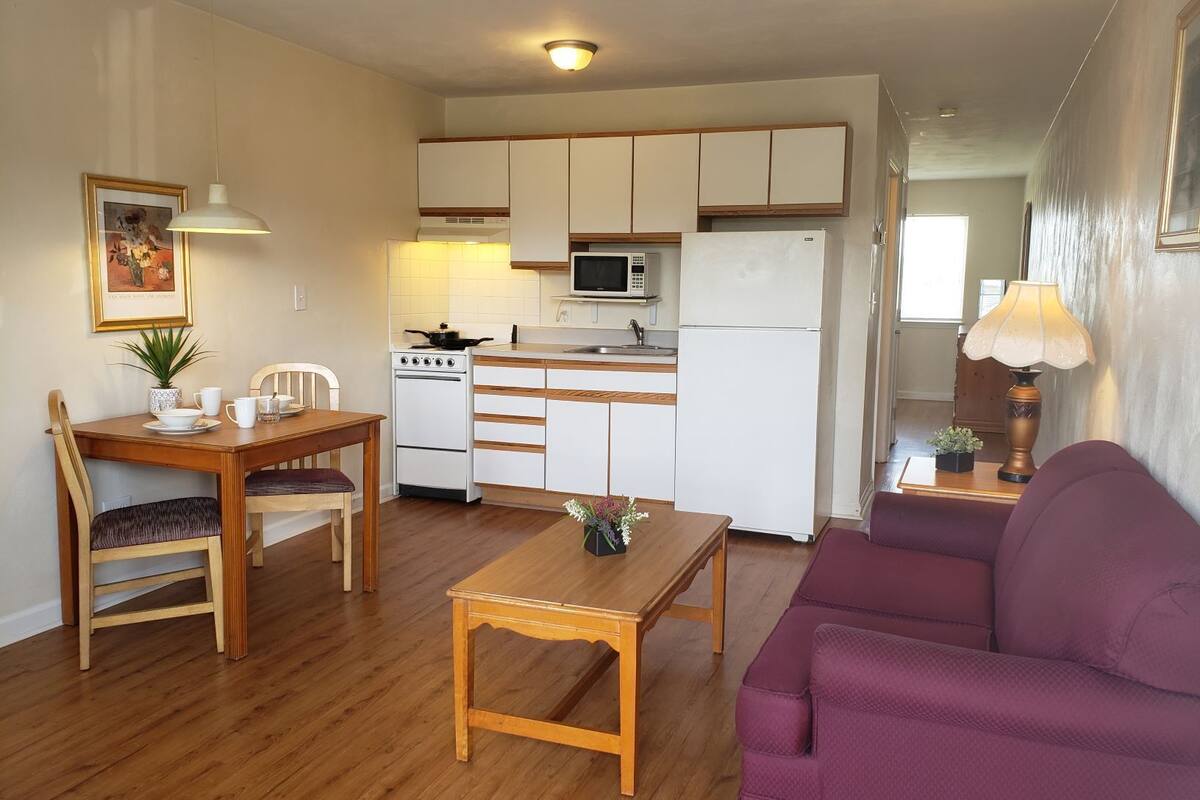 Een knus woongedeelte met een eethoek, kitchenette en een bank.
