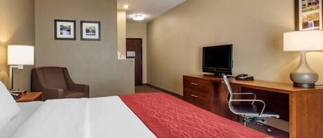 Une chambre d’hôtel équipée d’un lit, d’un bureau, d’une chaise, d’une télévision et d’une lampe.
