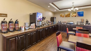 Un área de cocina de hotel con una estación de café, zona de asientos y un letrero que indica que es solo para empleados de cocina.