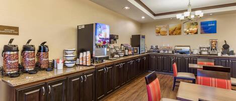 A hotel kitchen area with a coffee station, seating area, and a sign indicating it's for kitchen employees only.