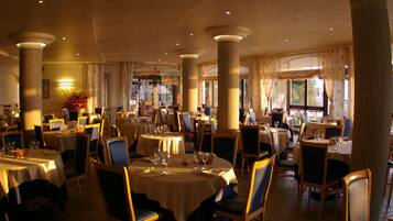A spacious restaurant with round tables, chairs, and a warm ambiance.