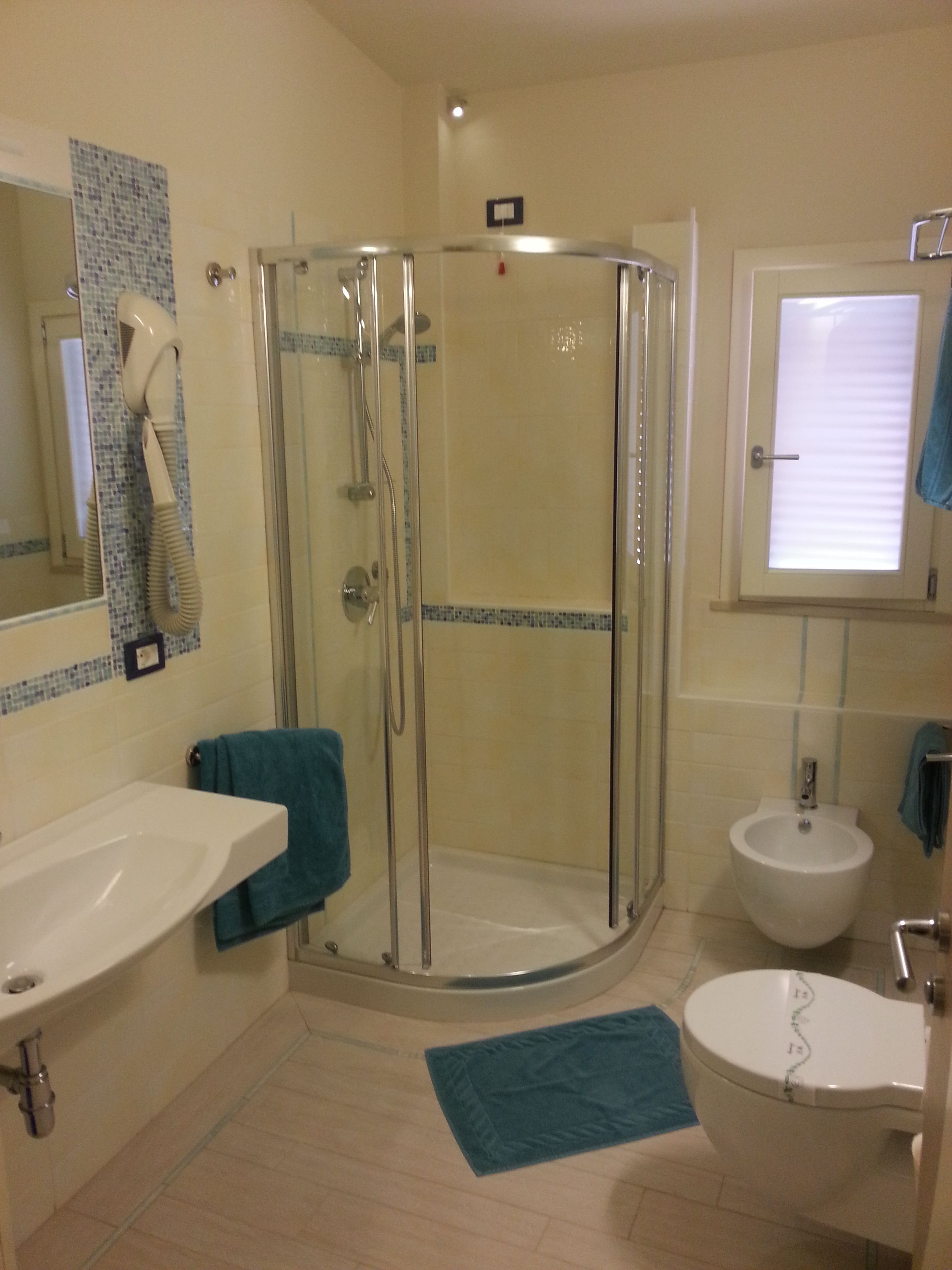 Ein Badezimmer mit Duschkabine, Waschbecken, Bidet und Toilette.
