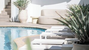 A poolside area with white lounge chairs and a potted plant. - Comfort Inn & Suites Levittown (Toa Baja)