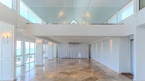 A spacious, high-ceilinged interior with a polished marble floor, large windows, and a glass railing overlooking a balcony. - Comfort Inn & Suites Levittown (Toa Baja)