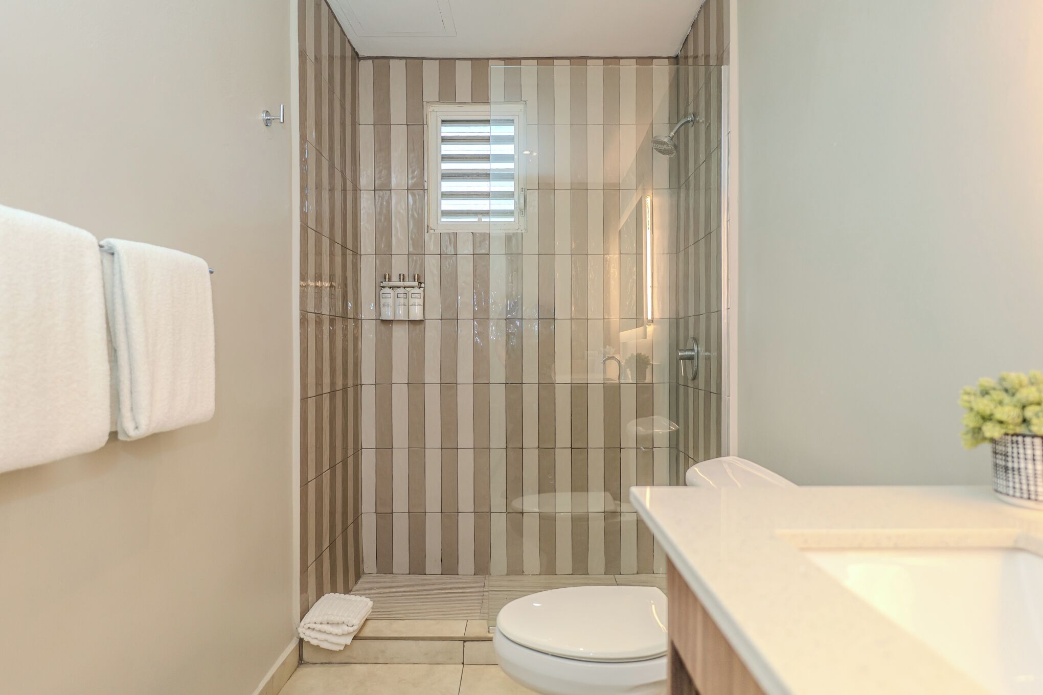 A bathroom with a shower, toilet, and sink.
