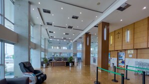 A spacious lobby with a reception desk, seating area, and a view of the street. - Praiamar Ponta Negra Hotel (Natal)