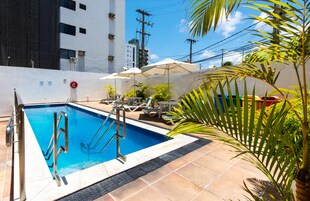 Una piscina al aire libre, sillones reclinables de piscina