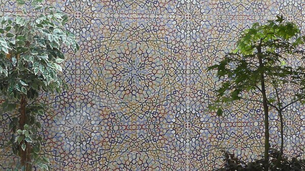 A mosaic wall with intricate geometric patterns. - Hotel Tingis (Paris)