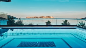 Una piscina azul y cristalina con vistas a una montaña distante y aguas tranquilas.