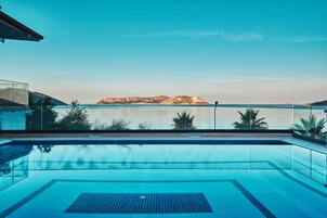 Una piscina azul y cristalina con vistas a una montaña distante y aguas tranquilas.
